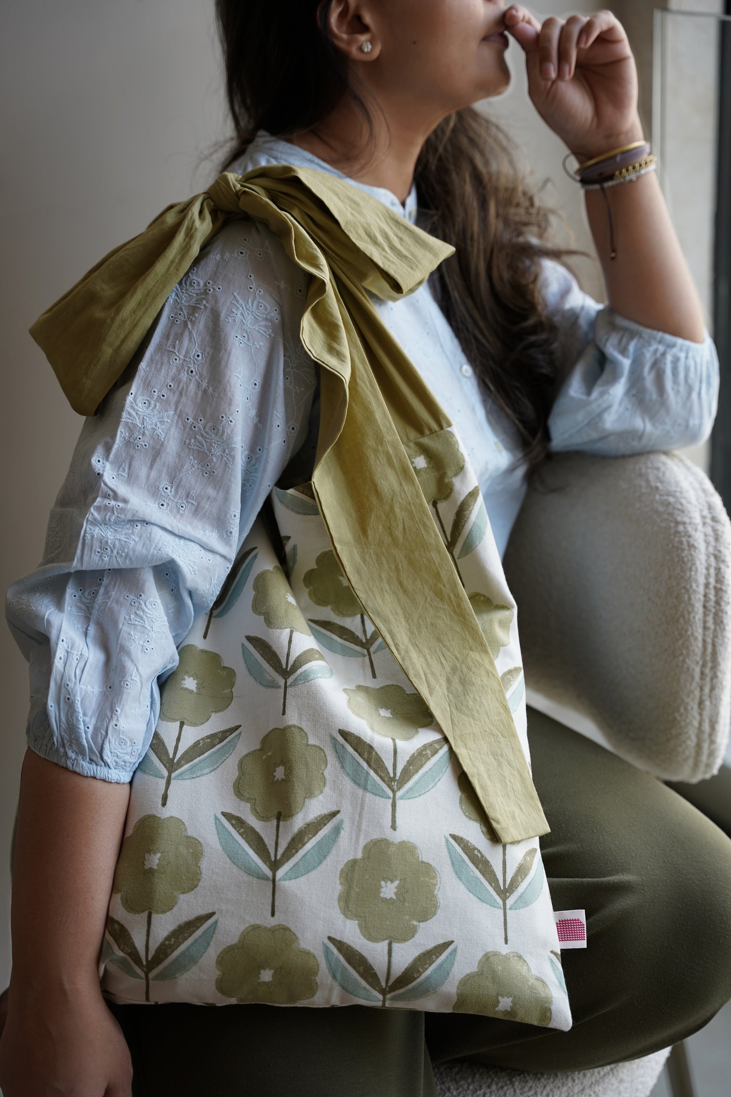 Floral-patterned bag with a green scarf