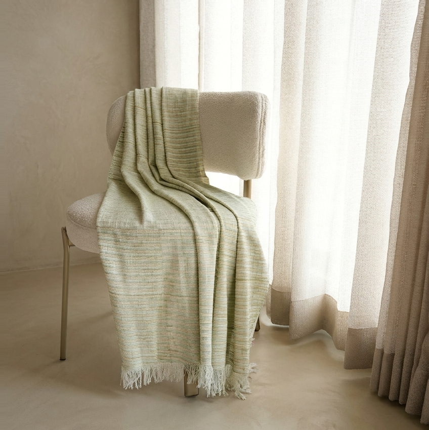 Stack of folded fabric on a white surface with a neutral background