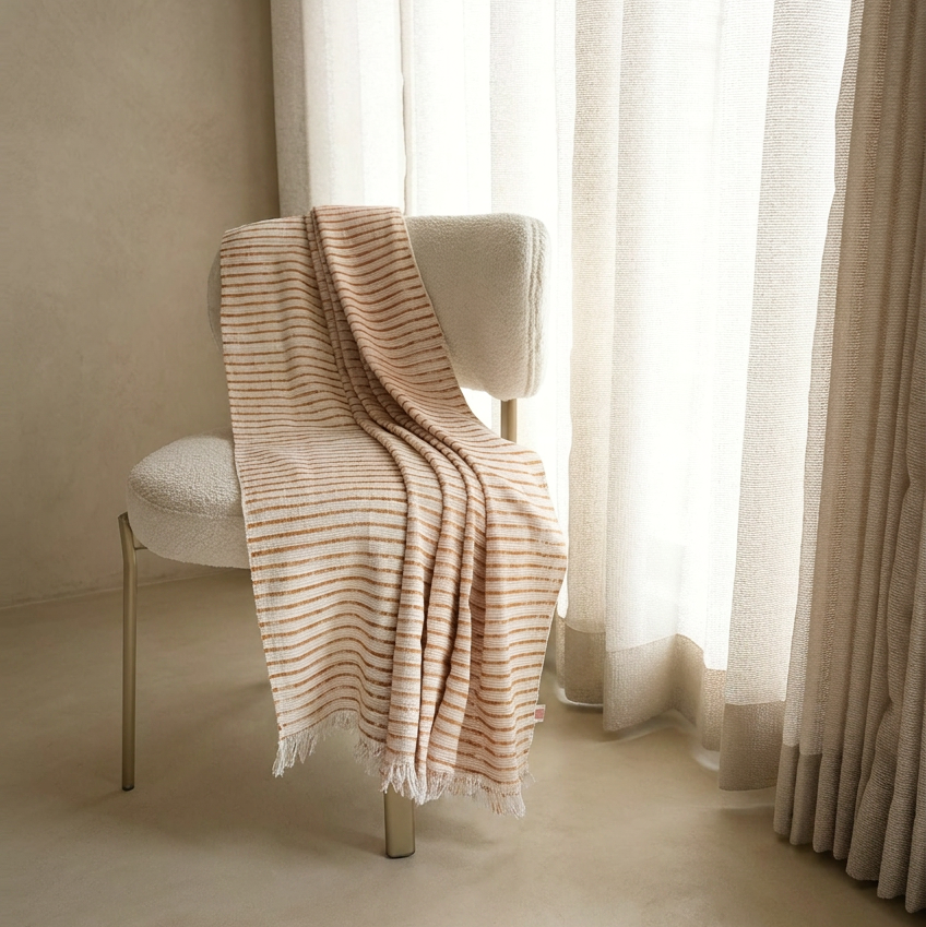 Folded beige fabric on a white surface with a neutral background